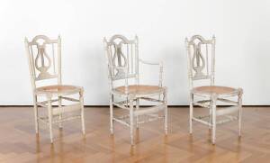 Three matching cream painted caned chairs, French, early 19th Century (one with arms)