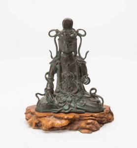 A bronze figure of a seated Bodhisattva on burl wood base, 18cm high including base.