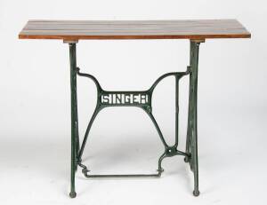 A "Singer" sewing machine treadle base timber top garden table.&nbsp;76cm high, 100cm wide&nbsp;