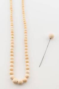 An ivory bead necklace and hat pin.