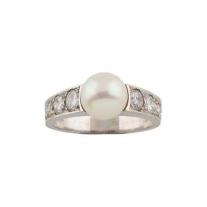 A pearl and diamond dress ring, the 8.2mm pearl set either side with round brilliant diamonds of estimated total weight 1.15 carats, 18ct white gold, size O.