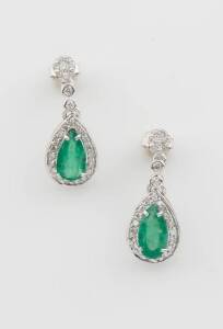 A pair of emerald and diamond earrings, the pear-shaped emerald drops of total weight 4.30 carats and surrounded by round by round brilliant diamonds of total weight 1.20 carats, stud fittings, 18ct white gold.