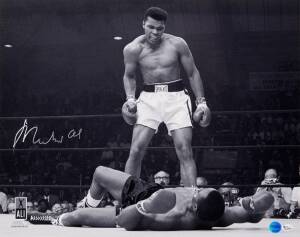 MUHAMMAD ALI, signed b/w photograph of Ali standing over Sonny Liston, size 51x41cm. With 'Online Authentics' No.OA-8090307.