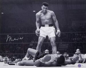 MUHAMMAD ALI, signed b/w photograph of Ali standing over Sonny Liston, size 51x41cm. With 'Online Authentics' No.OA-8090309.