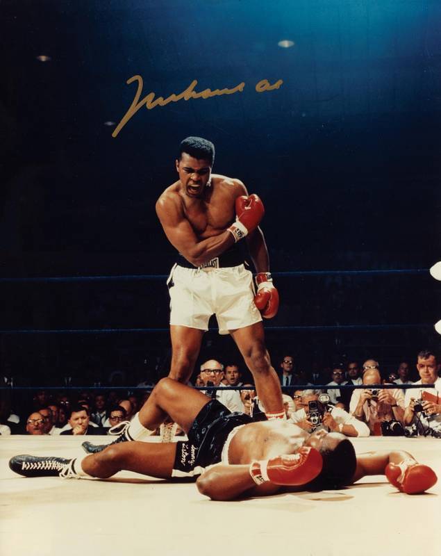 MUHAMMAD ALI, signed colour photograph of Ali standing over Sonny Liston, size 28x35cm. With CoA #0474.