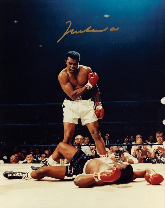 MUHAMMAD ALI, signed colour photograph of Ali standing over Sonny Liston, size 28x35cm. With CoA #0546.