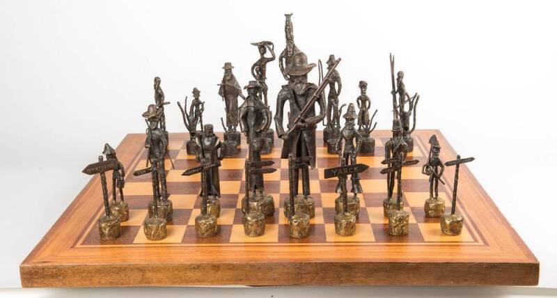 Australiana bronze chess set circa 1960s with Bushrangers verses Aboriginals. With accompanying inlayed timber folding games table. Tallest 29.5cm.