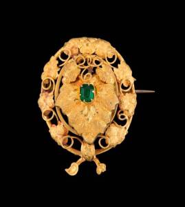 A locket brooch of foliate design by Thomas Wright, Melbourne, the hinged vine leaf front section set with a green paste stone, the applied three part bar mark with unattributed kangaroo mark, T.W. and crown. 18ct yellow gold, width 30mm.