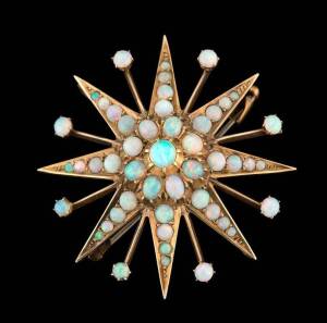 An opal starburst brooch, attributed to Willis of Melbourne, set with crystal opals. 15ct yellow gold, marks indistinct. Diameter 46mm.