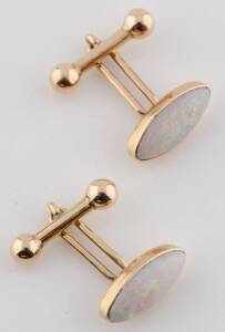 A pair of opal cufflinks, by Mc Bean, Melbourne. The marquise shaped solid white opals in 15ct yellow gold bezel set mounts. Impressed three part mark, star, and 15ct hanging fleece.