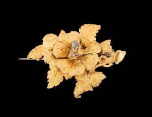 A gold brooch, of floral design, set with a central gold quartz specimen. The reverse inscribed E M S, 19th February 1877. Yellow gold.  Length 50mm. Provenance: Purchased from the estate of Bertha Florence Halstead, Ballarat.  Similar examples: Australia