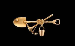 A Miner's brooch, crossed pick and shovel with bucket and three gold nuggets. Marked 18ct. Length 57mm. Weight 6.37 grams. Provenance: A private collection, Buninyong. To be sold in a cardboard box for C Marks & Co., Watchmakers and Jewellers, National Mu