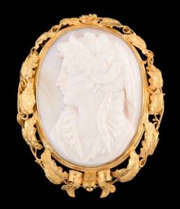 A gold foliate and cameo suite, the carved conch shells depicting classical female profiles within vine leaf and tendril mounts. Yellow gold. Diameter of brooch 48mm (Rear of photograph marked for Metcalf & Glaister, 1875, Queen Street, Brisbane.)