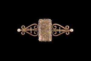 A gold quartz bar brooch, marked 9ct, length 47mm.