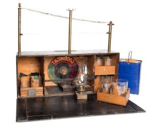 A magicians performance box, 19th Century, with oil lantern & an array of glasses & accessories. 60cm high, 68cm wide, 18cm deep