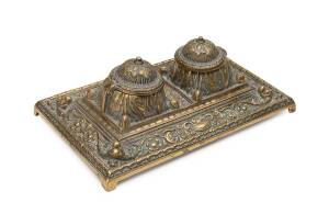 An ornate desk set, most likely English, brass with porcelain liners, late 19th Century. 8cm high, 24cm wide, 15cm deep