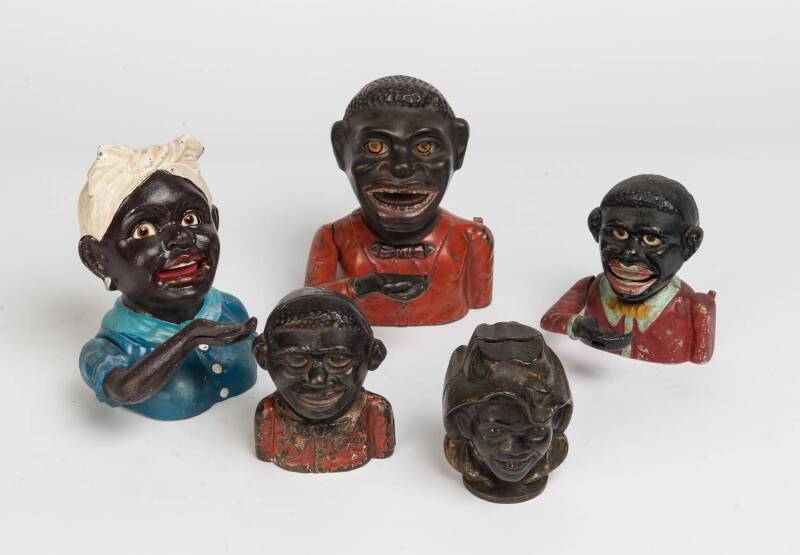 A collection of cast metal money boxes comprising a "Jolly Nigger" by the J & E Stevens Co, a replica John Harper box plus 3 other small boxes