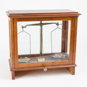 Balance scales & weights in mahogany & glass case, English, late 19th Century together with a set of five brass Endecott sieves used primarily for mining. The scales 33cm high, 34cm wide, 16cm deep