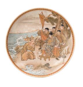 A small Japanese satsuma saucer, Meiji period (1868-1912), decorated with figures by the sea, signed: "Shosui" on the front, "Matsuura" to the base. 15.6cm diameter.