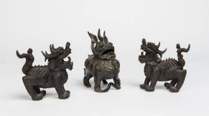 A Chinese bronze censer in the form of a Qilin on stand together with two metal dragon dogs. 19th Century & later. The Qilin 18cm high