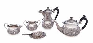 An Anglo-Indian silver tea service comprising 2 teapots, sugar basin, milk jug, tea strainer with horn handle & saucer, stamped "Sterling Silver", late 19th Century. Tallest 19.5cm. (6 items)