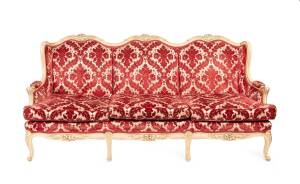 A Louis XV style painted three seater settee upholstered in red jacquard