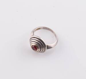 A ruby dress ring, the ruby set in a contemporary stepped setting. Silver and yellow gold. Ring size L. Maker's mark Tarasin, Sydney. 