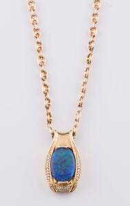 An opal pendant on chain, the oval opal crystal mounted in a diamond set frame. 18ct yellow gold. Weight 10.70 grams.  Hung on a 9ct yellow gold chain. Weight 13.06 grams. 