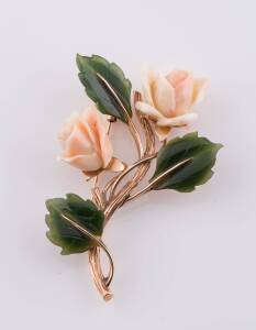 A coral and jadeite brooch, of floral spray design. Not marked, testing as 12ct rose gold. Weight 23.50 grams. Length 7cm.&nbsp;