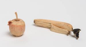 Two bone carved fruits, banana & apple, 20th Century. The banana 11cm long