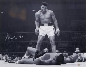 MUHAMMAD ALI, signed b/w photograph of Ali standing over Sonny Liston, size 51x41cm. With 'Online Authentics' No.OA-8090310.
