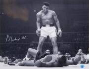 MUHAMMAD ALI, signed b/w photograph of Ali standing over Sonny Liston, size 51x41cm. With 'Online Authentics' No.OA-8090311.