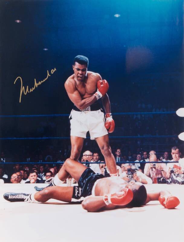 MUHAMMAD ALI, signed colour photograph of Ali standing over Sonny Liston, size 41x51cm. With CoA #64689.