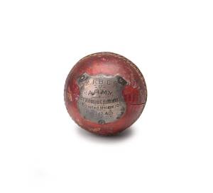 BALL THAT BOWLED BRADMAN: Cricket Ball with shield attached, engraved "M.F.B.C.C v ARMY, Bradman C.Buttsworth, Bowled McKimm 109. 11.12.40". Bradman's 109 raised 2/6 for each run scored against the Fire Brigade bowlers for the "Fags For Fighters Fund". [W