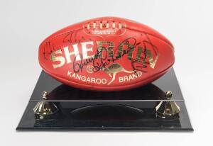 "Sherrin" football with 8 signatures including James Hird, Gerard Healy & Doug Hawkins, in perspex display case.