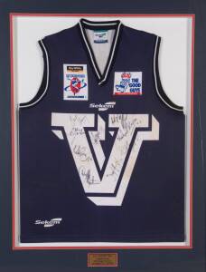 E.J.WHITTEN LEGENDS GAME: Victorian jumper match-worn by Warwick Capper in 2005, with 9 signatures on front including Nathan Burke & Dermott Brereton, window mounted, framed & glazed, overall 86x108cm.