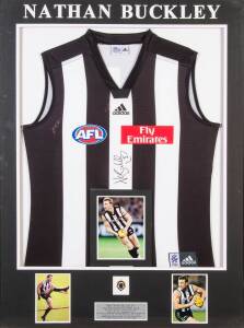 NATHAN BUCKLEY: Signed Collingwood jumper, window mounted with replica Brownlow Medal & three photographs; framed & glazed, overall 81x109cm. With CoA.