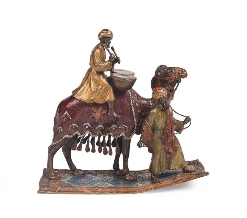 An Austrian cold painted bronze of a camel ridden by a Bedouin playing drums and an attendant, in the manner of Franz Bergman, 18 cm high