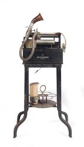 An early Dictaphone machine patented as "The Dictaphone", Circa 1903 with original stand, cords & a cylinder. 88cm high. together with a similar Dictaphone with no stand