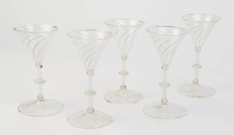 A set of five white enamel twist wine glasses with knopped stems