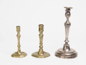 Two brass candle sticks, 18th Century, together with a silver plated candle stick. Tallest 30cm. 