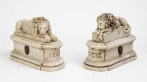 A pair of carved and molded composite marble recumbent lion figures. 30cm high, 40cm wide, 18cm deep. 