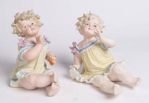 A pair of European bisque porcelain figures of seated infants, circa 1900 27cm high