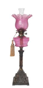 A ruby glass kerosene lamp with cast metal base & double burner. 