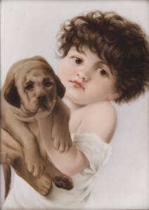 A German porcelain framed panel painted with a young boy holding a puppy, 17 x 12 cm