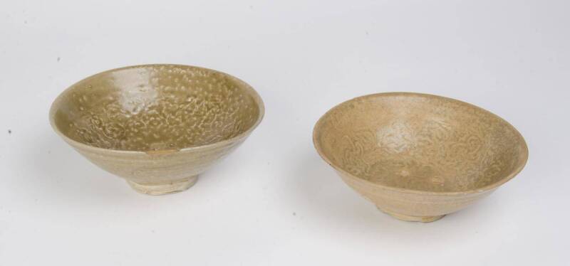 Two large molded celadon bowls, circa 14th Century. 21.5cm and 20.5cm diameter