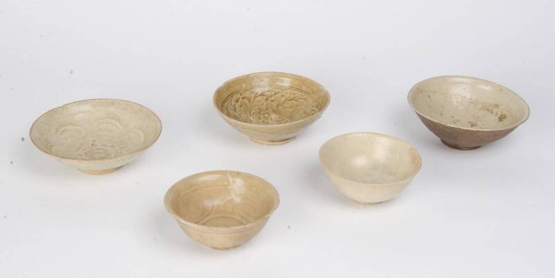 Five celadon bowls with incised or moulded decoration, circa 14th Century, 13cm to 16.5cm diameter