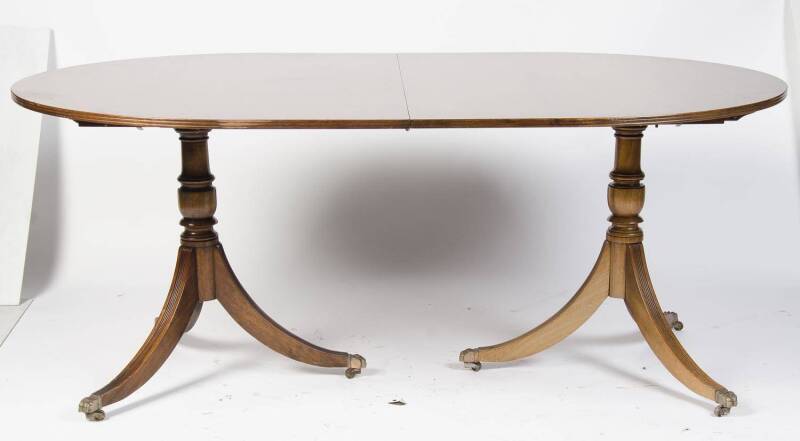 A George III style mahogany twin pedestal extension dining table, 20th Century. 742cm high, 230cm wide, 115cm deep.