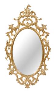 A pierced and carved oval giltwood salon mirror, 20th Century. 132cm high, 72cm wide