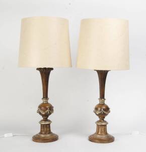 A pair of carved, painted and silvered wooden lamps with cream marbled shades 